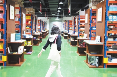 5月5日，在賀蘭縣德勝工業(yè)園區(qū)的新華書店德勝倉賣場，一位市民在書架間穿梭。該賣場由占地面積1600平方米的書店倉庫轉(zhuǎn)型而來，人們可以推著購物車，像在超市一樣穿梭在書架間選購圖書。賣場書籍總量超過10萬冊，還著重營造閱讀環(huán)境，設(shè)置了閱讀區(qū)、文創(chuàng)區(qū)等區(qū)域。    本報記者  季正  攝