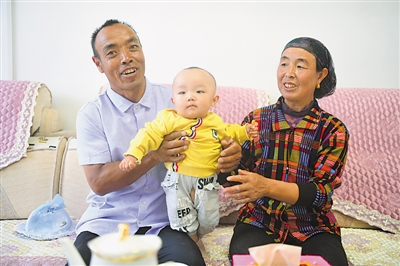 <p>　　劉克瑞（左）和妻子在客廳中陪孫子玩耍?！【緢笥浾摺●R楠　攝</p>